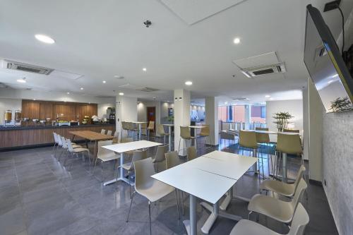 a dining area with tables and chairs in a cafeteria at City Express by Marriott Veracruz in Veracruz
