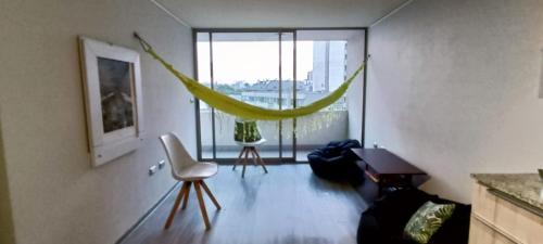 a living room with a hammock in front of a window at Acogedor departamento 2 Habitaciones y 2 baños Santiago de Chile in Santiago