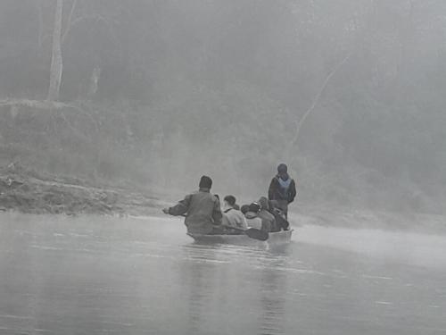 a group of people in a boat on a river at Crocodile Safari Camp in Chitwan