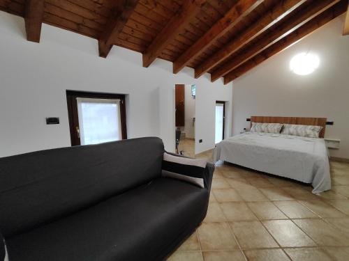 a living room with a bed and a couch at Casa Ninetta in Borgomanero