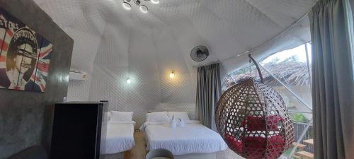 a room with two beds and a large window at นรดีฮิวล์ รีสอร์ต เขาแผงม้า วังน้ำเขียว in Ban Sap Bon