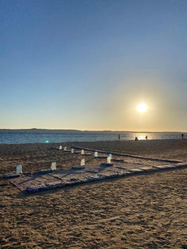 a beach with the sun setting over the water at Blend in Nature Eco Camp Beachfront Stay in Ras Mohamed, Sharm El Sheikh in Sharm El Sheikh