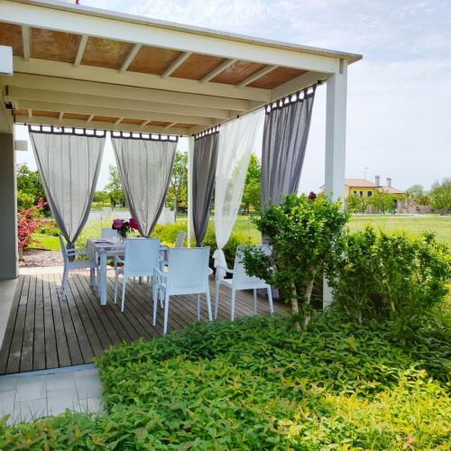 a patio with a table and chairs under a pergola at Ca' Belvedere in Sant'Elena di Silea