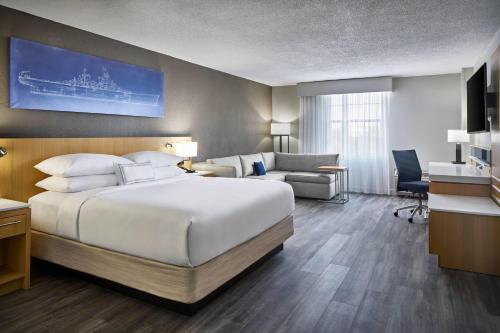 a hotel room with a large bed and a desk at Delta Hotels by Marriott Norfolk Airport in Norfolk