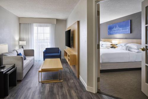 a hotel room with a bed and a couch at Delta Hotels by Marriott Norfolk Airport in Norfolk