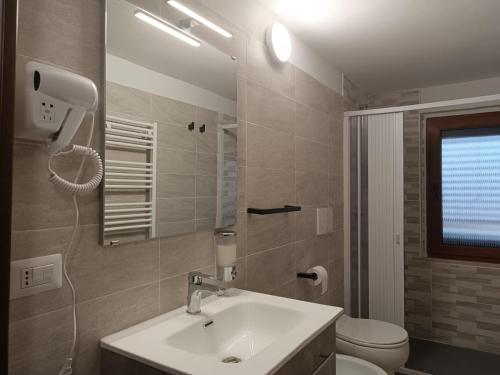 a bathroom with a sink and a toilet and a mirror at VILLA VIOLA B & B in Baganzola