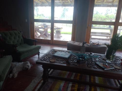 ein Wohnzimmer mit einem Couchtisch und einem Hund in der Unterkunft Casa de campo Chincha Guayabo 