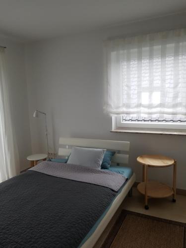 a bedroom with a bed with a window and a stool at schöne Wohnung in Bad Nauheim, nahe Frankfurt in Bad Nauheim