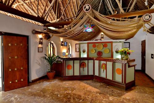 a room with a table and a hammock hanging from the ceiling at Mnarani Beach Club in Kilifi