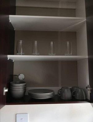 uma prateleira de cozinha com pratos e copos em Noble Luminous Accommodation and Tours em Rehoboth