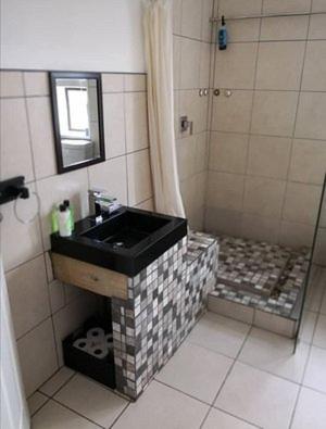 uma casa de banho com um lavatório e um chuveiro em Noble Luminous Accommodation and Tours em Rehoboth