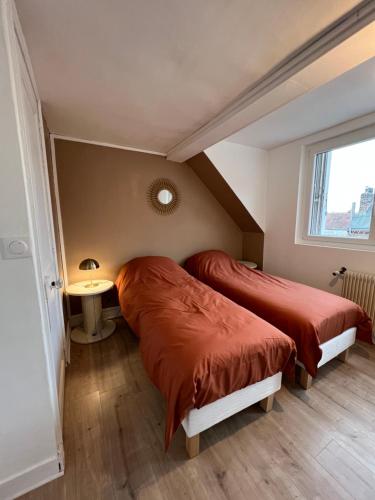 2 Betten in einem kleinen Zimmer mit Fenster in der Unterkunft Maison la Dieppoise in Dieppe