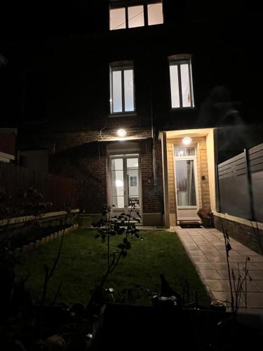 ein nachts beleuchtetes Haus mit einer Eingangstür in der Unterkunft Maison la Dieppoise in Dieppe