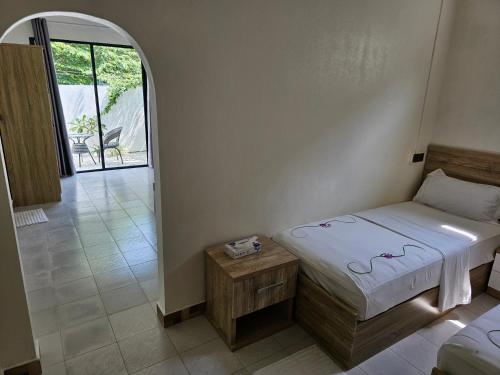 um pequeno quarto com uma cama e uma mesa em Island Luxury Fehendhoo em Fehendhoo