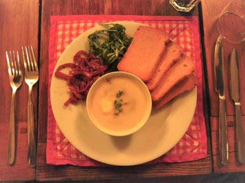 a plate of food with a bowl of soup and toast at Chalet Garibaldi - Total Chalets in Bansko