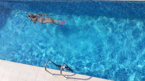 a man swimming in a large blue swimming pool at Mavi Panorama Villa in Cesme