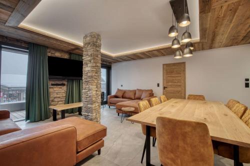 un salon avec une table et un canapé dans l'établissement Lodge des Glaciers - La Rosière, à Montvalezan