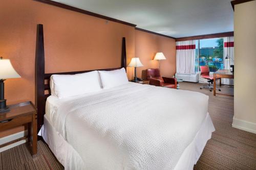堪薩斯城的住宿－堪薩斯城機場福朋喜來登酒店，卧室配有一张白色大床和一张书桌