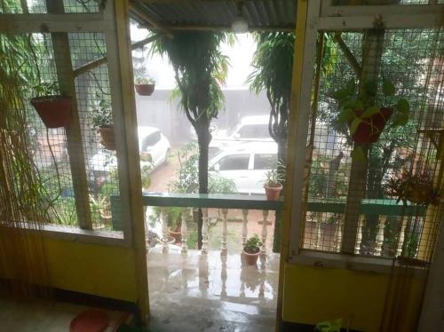 une porte ouverte avec vue sur un parking dans l'établissement Hemalata Heritage Home, à Guwahati