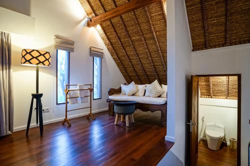 a living room with a couch and some windows at Pondok Santi Estate in Gili Trawangan