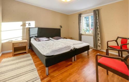 a bedroom with a large bed and a red chair at Solvik 2 in Hornbetan