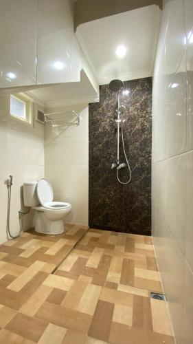 a bathroom with a toilet and a shower at Ghani Villa in Tlekung