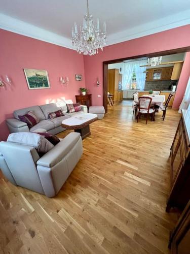 a living room with pink walls and white furniture at Wespartment Marienbad - City meets Nature in Mariánské Lázně