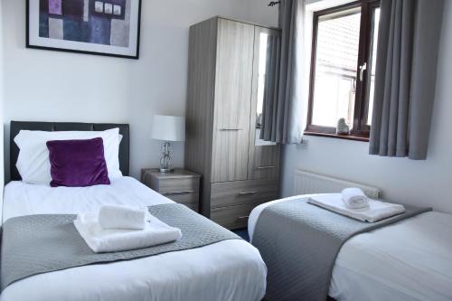 a bedroom with two beds with towels on them at Greenfield House in Norwich