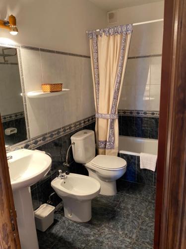 a bathroom with a toilet and a sink at LOS CARBAYINOS in Villaviciosa