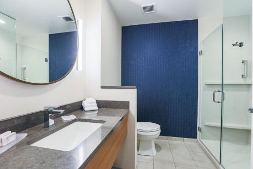a bathroom with a sink and a toilet and a mirror at Fairfield Inn & Suites Marquette in Marquette