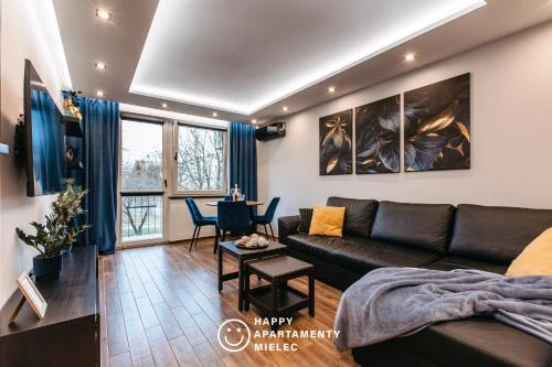 ein Wohnzimmer mit einem Sofa und einem Tisch in der Unterkunft Happy Time - Happy Apartamenty Mielec in Mielec