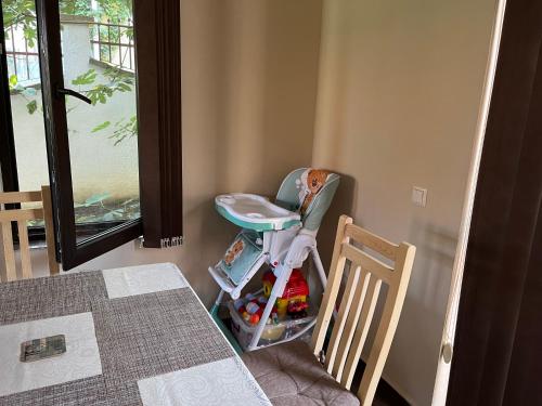 Un cochecito de bebé sentado junto a una mesa en una habitación en Villa Dimi en Sinemorets