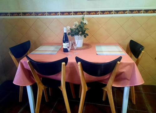 uma mesa rosa com cadeiras e uma garrafa de vinho em Mi Parchita em Valverde