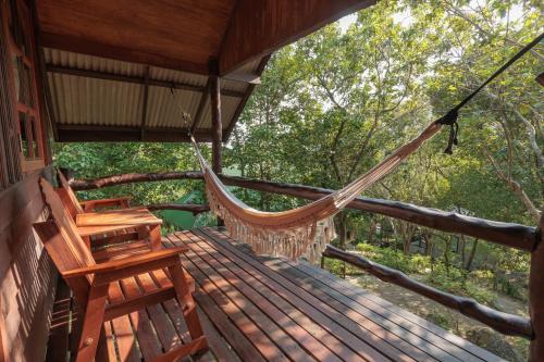 a hammock on the porch of a tree house at Why Nam Beach in Haad Yuan
