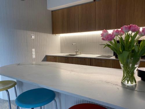 eine Küche mit einer Vase rosa Blumen auf der Theke in der Unterkunft Studio Heinrich 1 in Tutzing