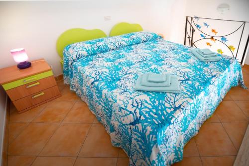 a bedroom with a bed with a blue comforter at Casa vacanze "Il Baffo e il Mare" in Cetara