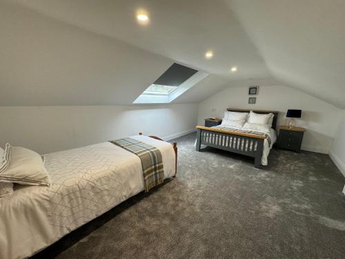 a attic bedroom with two beds and a window at The Hazel Tree BnB 
