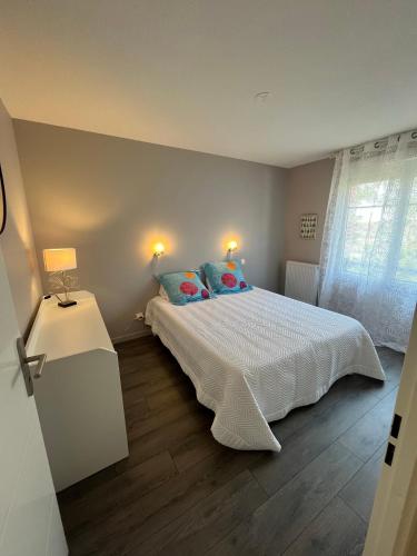 une chambre avec un lit blanc et une fenêtre dans l'établissement Appartement calme et cosy à Andernos-Les-Bains, à Andernos-les-Bains