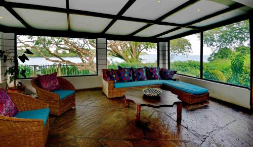 a living room with couches and a table and windows at Mnarani Beach Club in Kilifi