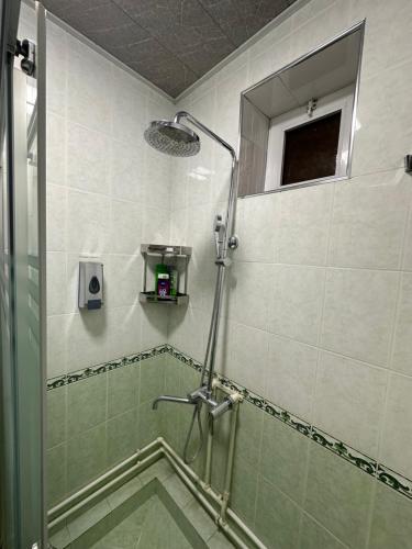 baño con ducha y puerta de cristal en Guest house Chehra, en Samarkand