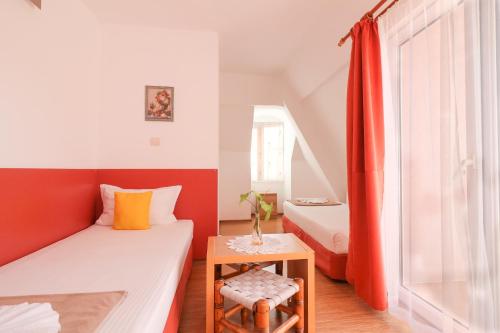 a small room with two beds and a table at Family Hotel Flora in Zlatograd