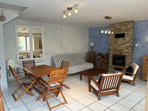 ein Wohnzimmer mit Tisch und Stühlen und einer Couch in der Unterkunft Gîte du Port in Ploubazlanec
