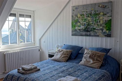 1 dormitorio con 1 cama con sábanas y almohadas azules en Le Gîte de Ker Ehden classé 3 étoiles en Ploubazlanec