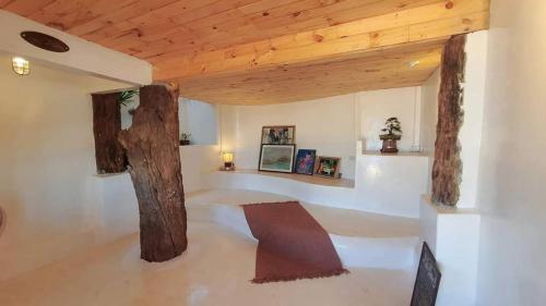 uma sala de estar com um tecto de madeira e um banco em Maliblues Bed & Art Gallery em Chumphon