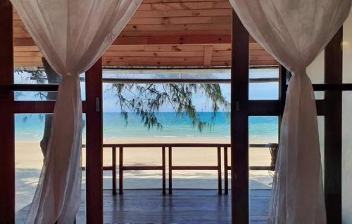 a view of the beach from a room with curtains at Maliblues Bed & Art Gallery in Chumphon