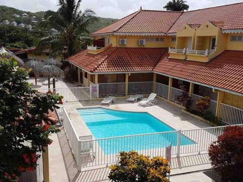 an aerial view of a house with a swimming pool at Joli studio Coeur de Canne piscine et plage en Martinique in Les Trois-Îlets