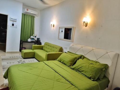- une chambre avec un lit vert et un canapé dans l'établissement PD ROOM STAY, à Port Dickson