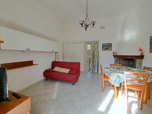 トッレ・サン・ジョヴァンニ・ウジェントにあるAppartamento La Torreのリビングルーム(赤い椅子、テーブル付)