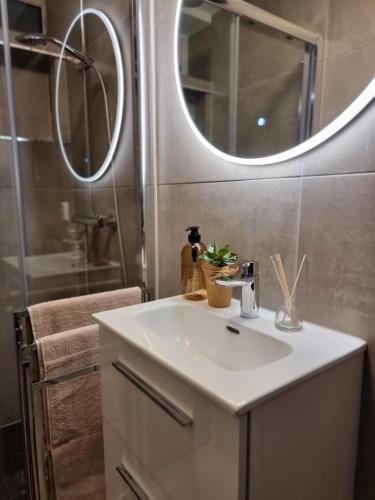 y baño con lavabo blanco y espejo. en Studio Apartament NORDBAKKEN, Perfect for World Cup Trondheim 2025 ONLY 1700m to SKI SENTER GRANÅSEN, en Trondheim