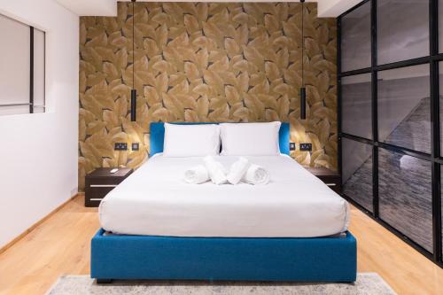 a bedroom with a large bed with two towels at Florette Suite 1BR with Stunning Lounge Terrace by ArcoBnb in Il-Furjana